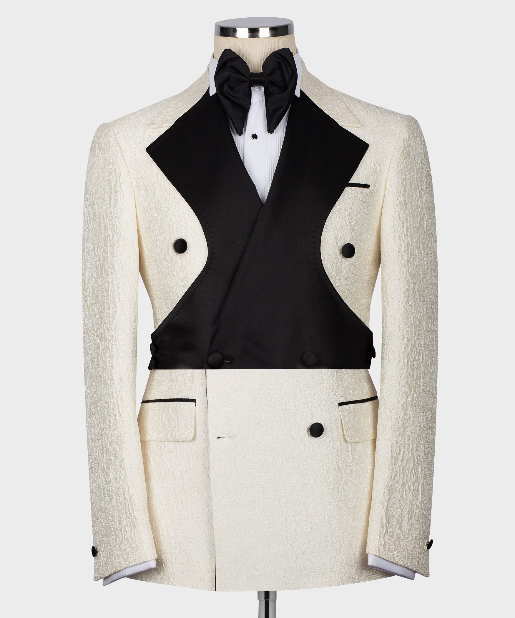 Cream textured tuxedo jacket with black satin vest, bow tie, and white shirt front