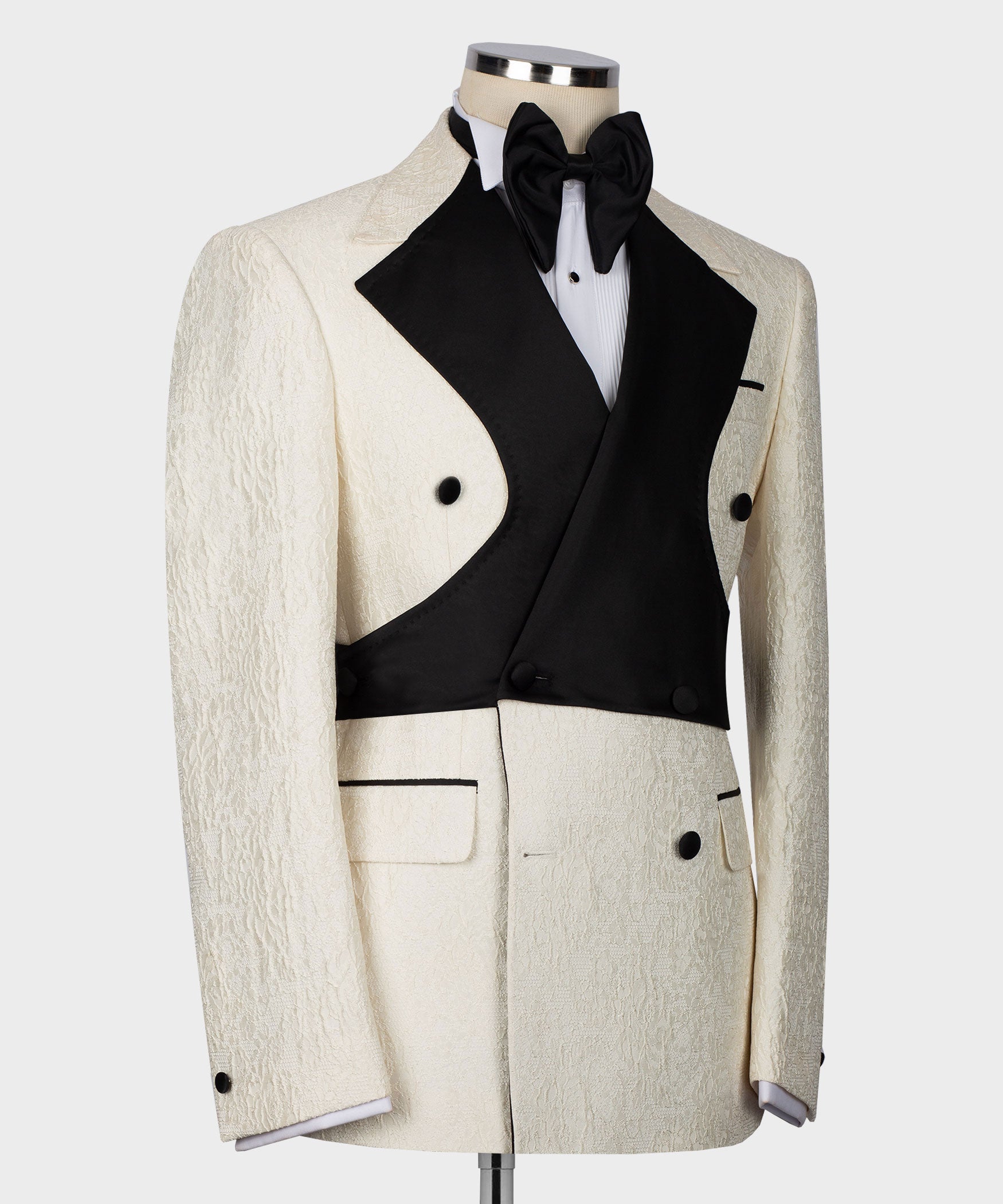 Side view of cream tuxedo jacket with black satin vest and black bow at the collar