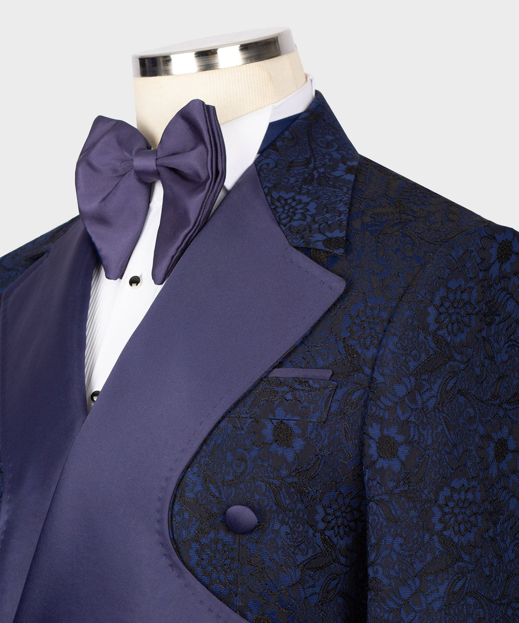 Navy tuxedo jacket close-up with satin bow tie, peaked lapels and floral texture