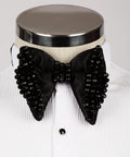 Koss Atelier black silk bow tie featuring intricate black bead embellishments on a white formal shirt.