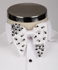 Koss Atelier white silk bow tie featuring black and silver crystal flower embellishments on a white pleated dress shirt.