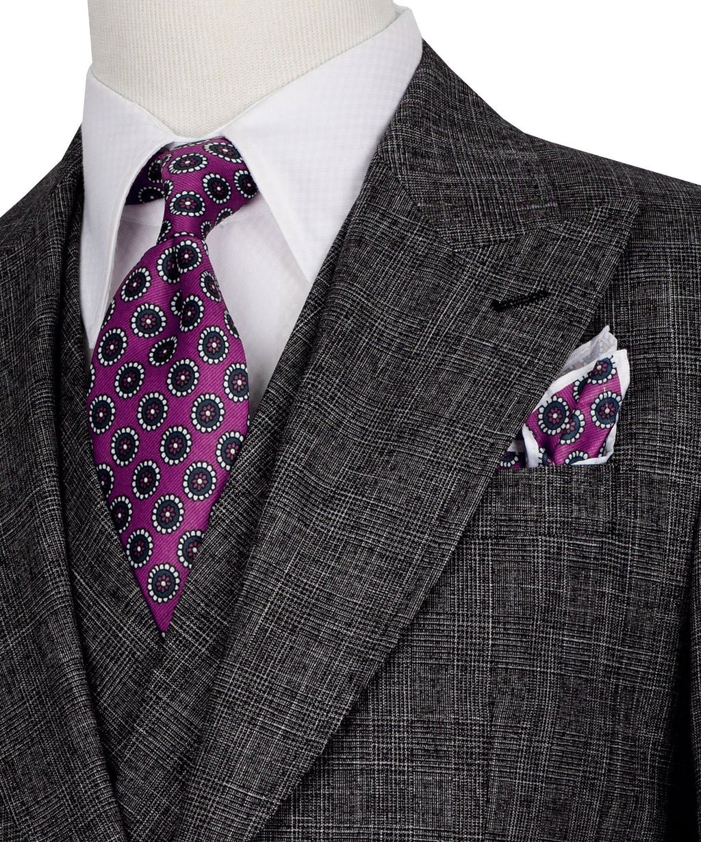 Purple patterned tie with matching pocket square on black plaid suit jacket