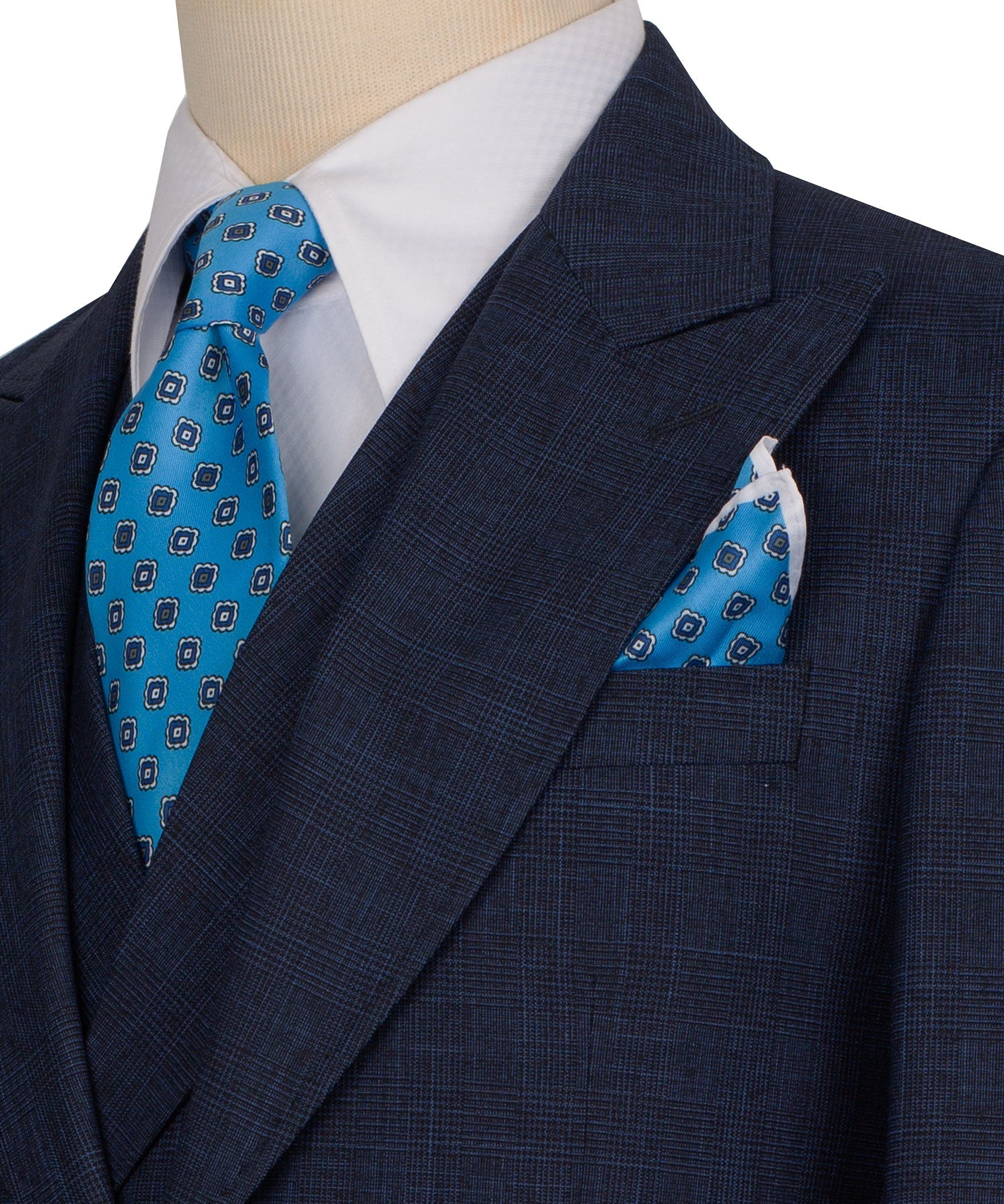 Close-up: dark navy suit lapel with blue patterned tie and matching pocket square