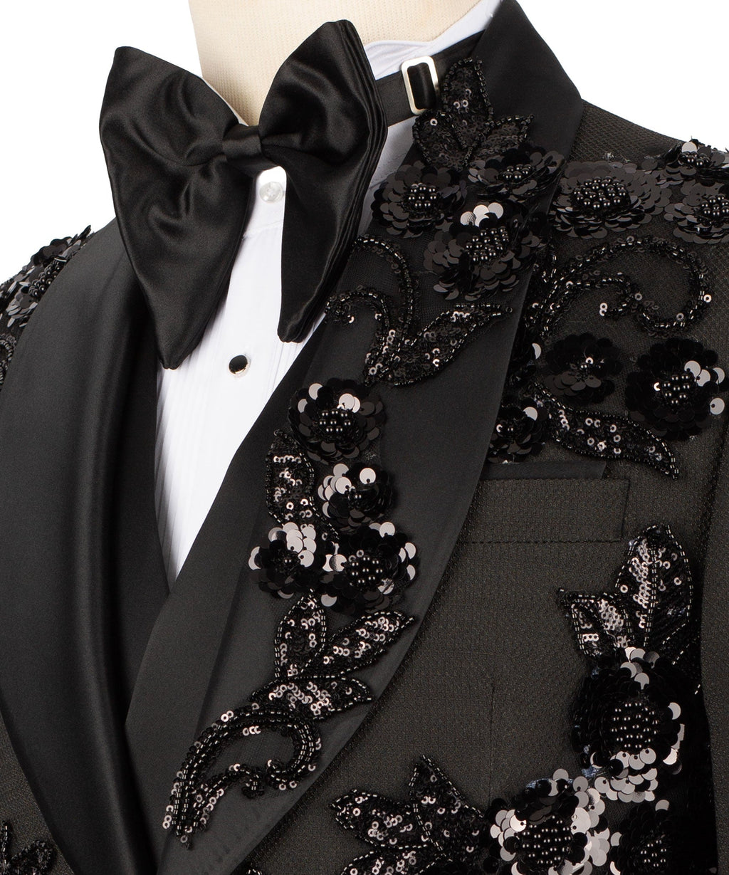 Close-up of black tuxedo jacket lapel with sequined floral pattern and satin bow