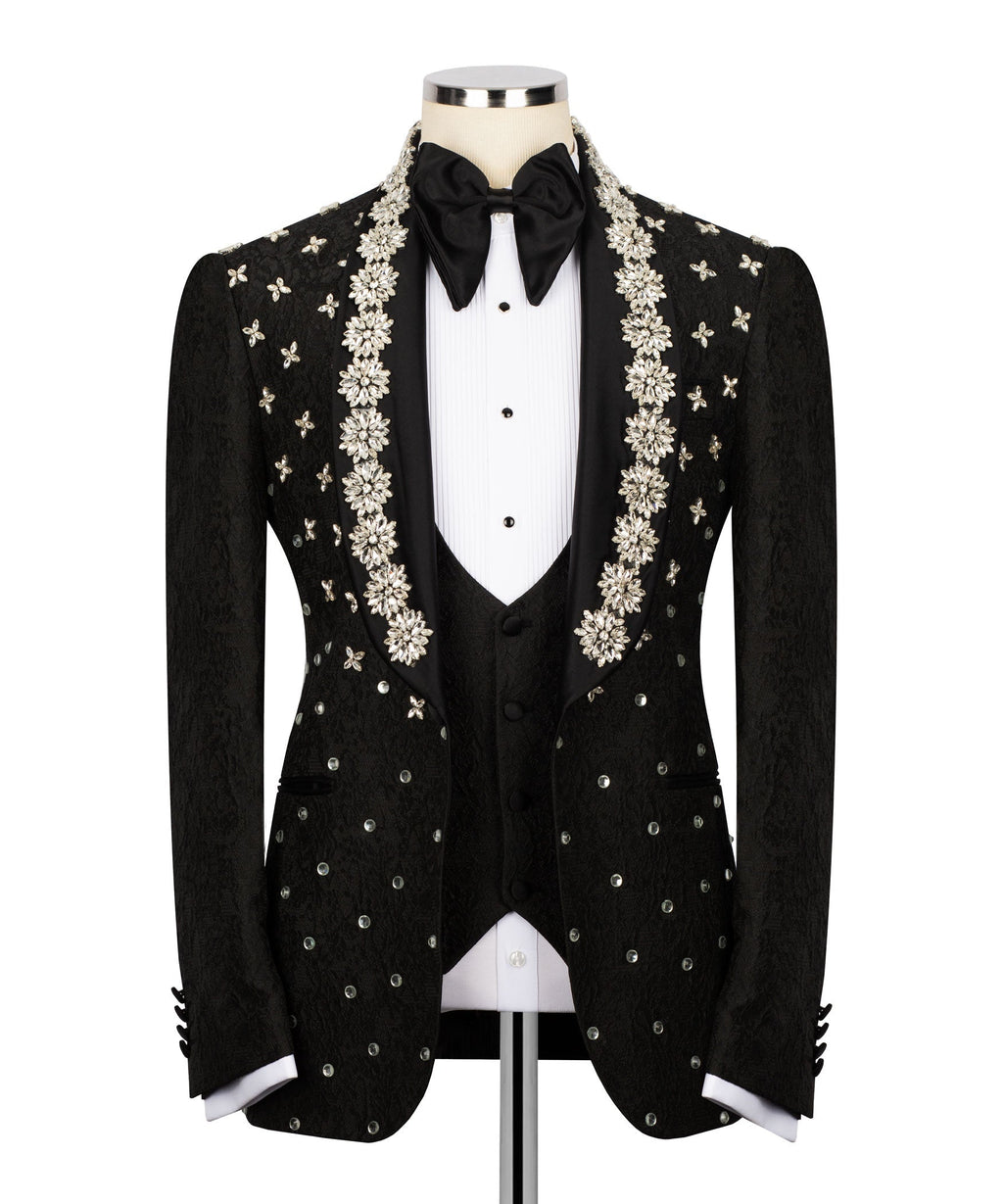 Black tuxedo jacket with floral-beaded embroidery, bow tie, and satin lapels over vest