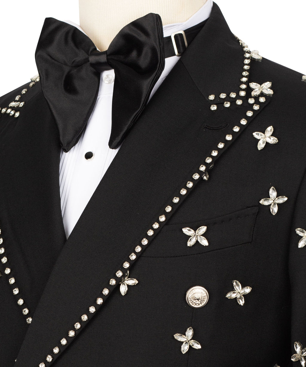 Black tuxedo jacket close-up: rhinestone diagonal stripe and butterfly appliqués