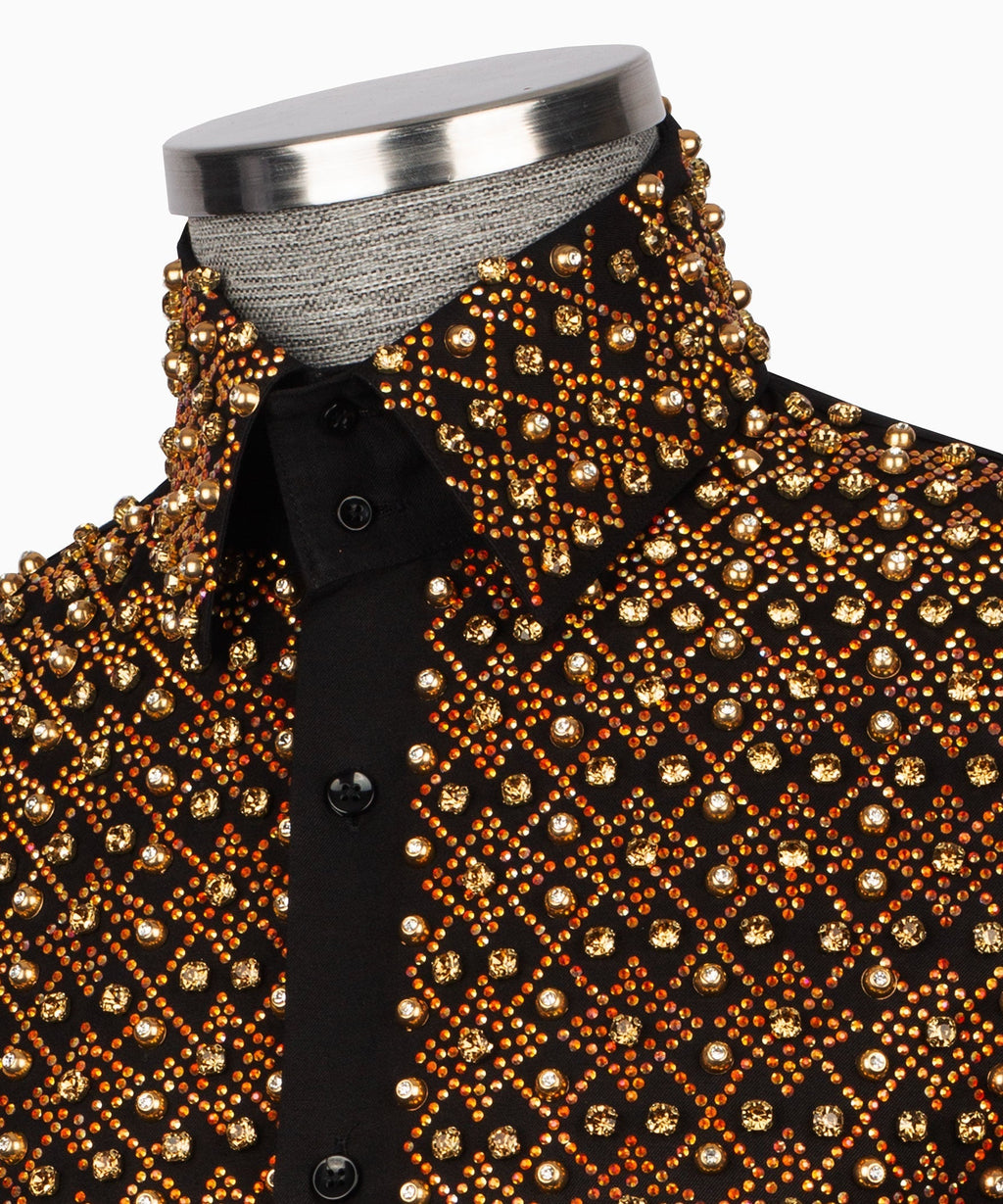 Close-up of black shirt front with dense gold stone embroidery and black buttons