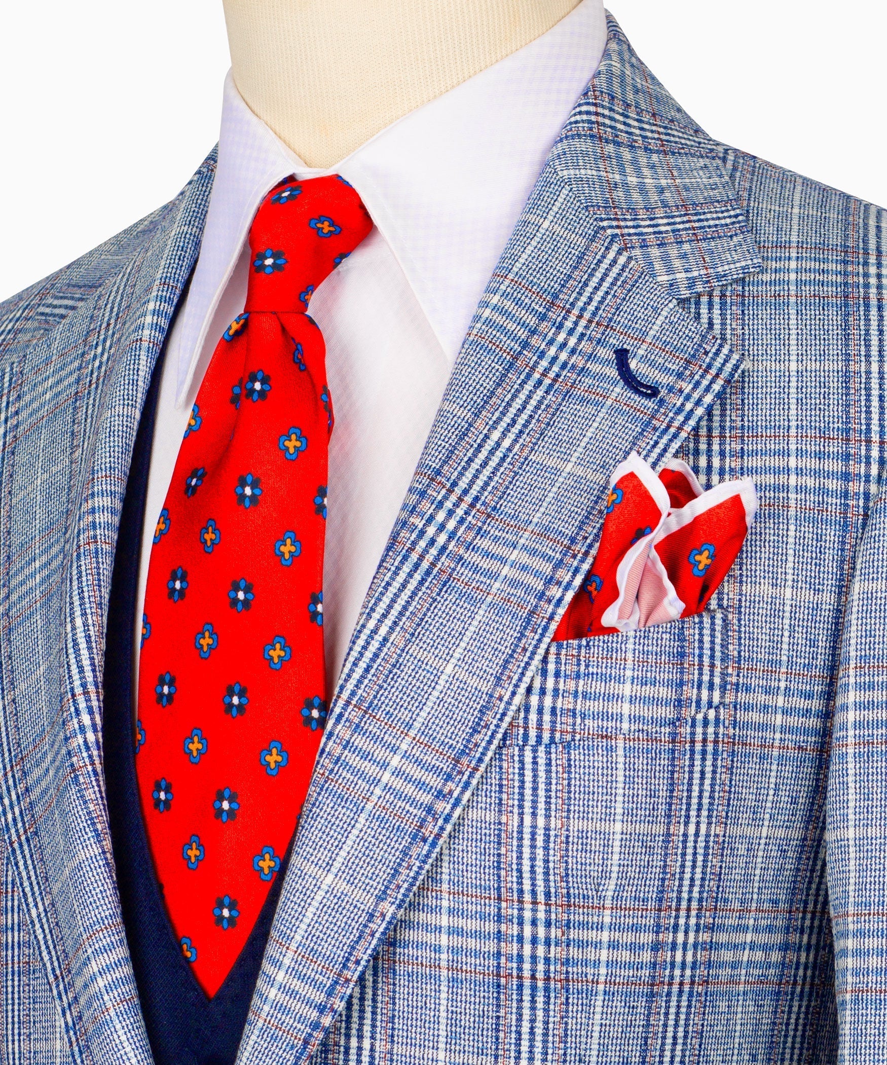 Close-up plaid suit jacket with red patterned tie and folded white pocket square