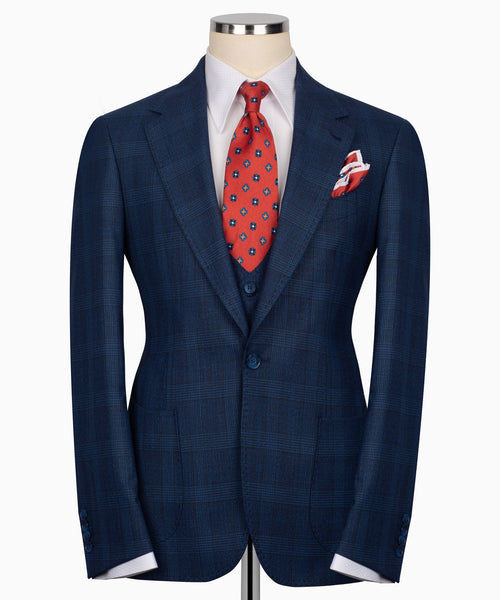 Navy plaid blazer with vest front, red patterned tie, and pocket square
