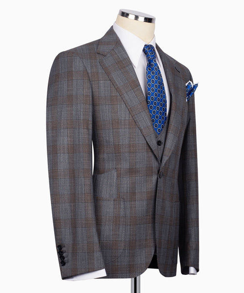 Grey plaid suit jacket with black vest and blue patterned tie, side view