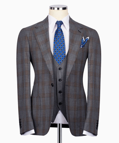 Grey plaid men’s suit jacket with black waistcoat, blue patterned tie and pocket square