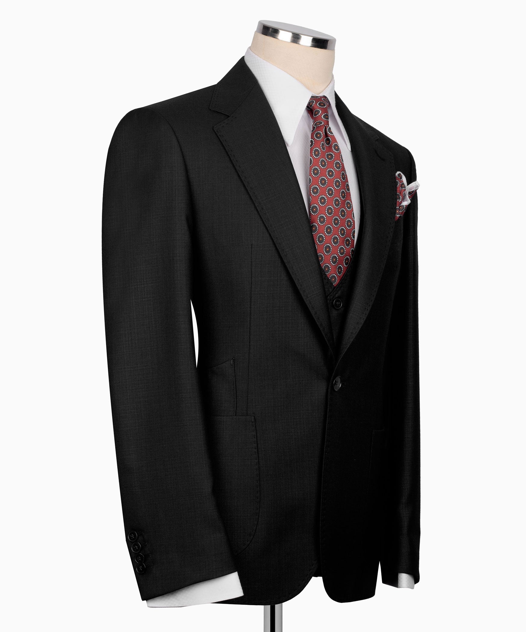 Black suit jacket side view with welt pocket and patterned pocket square on lapel.