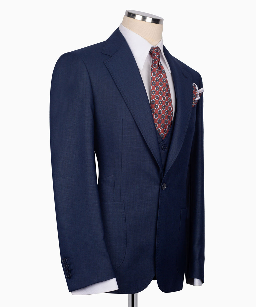 Navy plaid three-piece suit jacket and vest with patterned tie and folded pocket square
