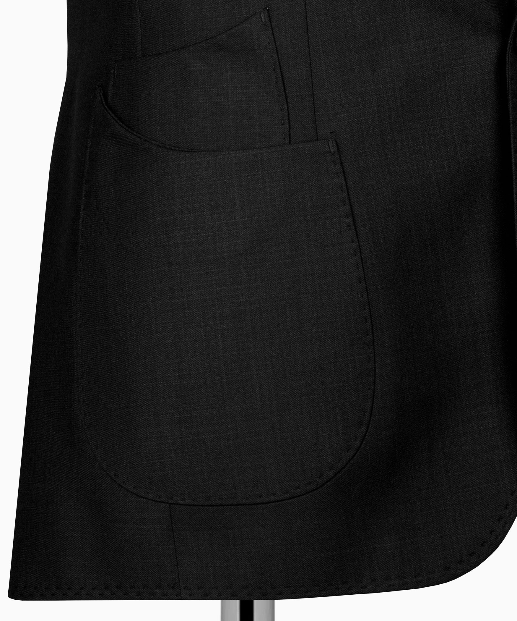 Black suit jacket lower front with curved welt pocket detail.