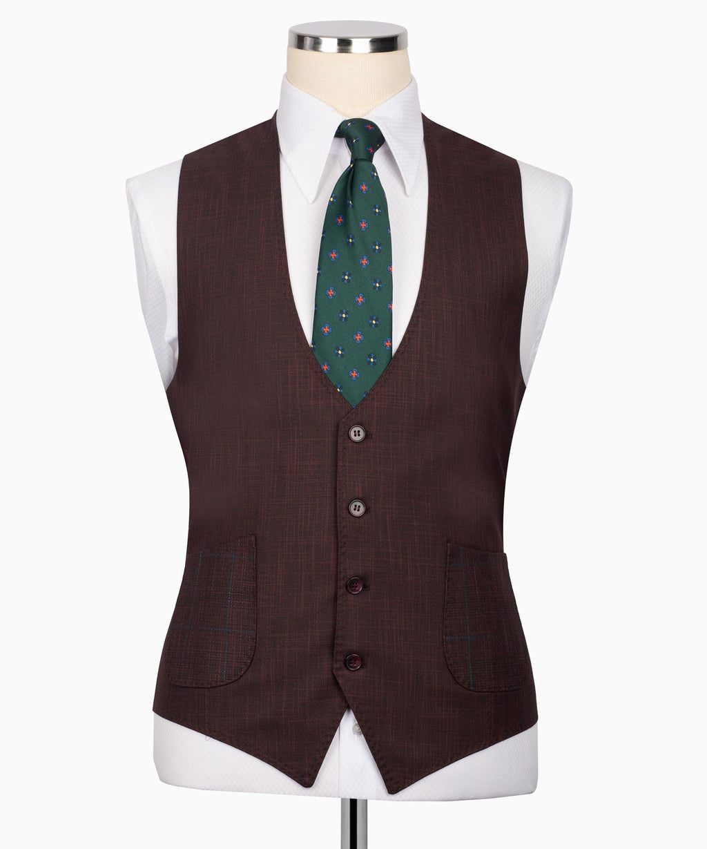 Plaid three-piece suit vest styling with green patterned tie and matching pocket details