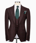 Men’s three-piece plaid suit jacket with green patterned tie and matching pocket square