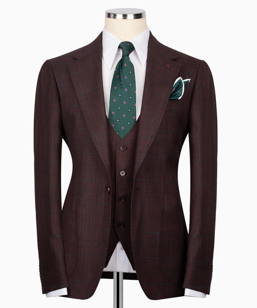 Men’s three-piece plaid suit jacket with green patterned tie and matching pocket square