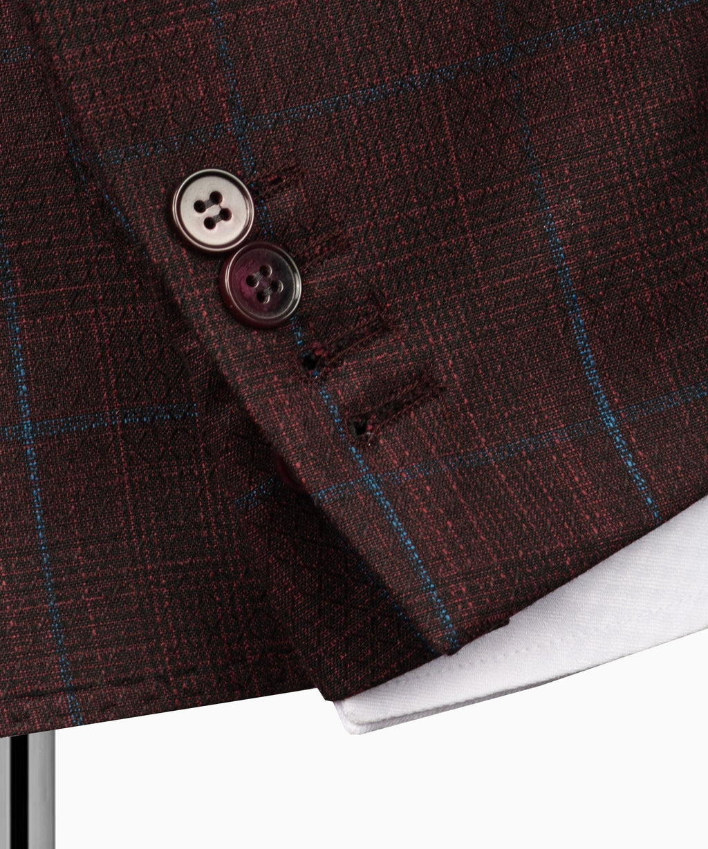 Plaid suit jacket cuff and button detail on maroon fabric with blue grid lines