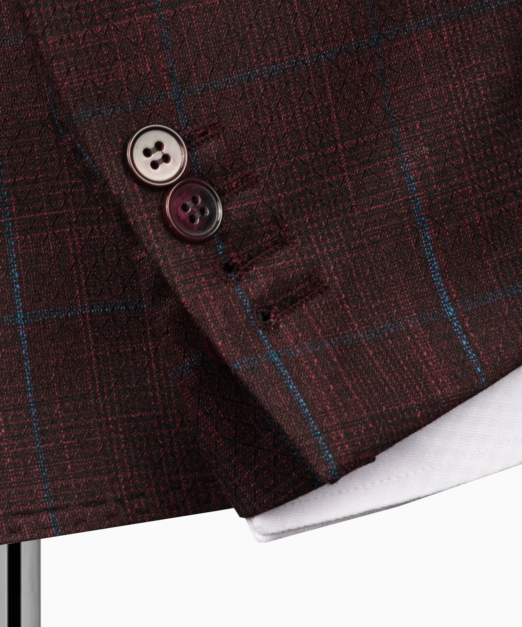 Plaid suit jacket cuff and button detail on maroon fabric with blue grid lines