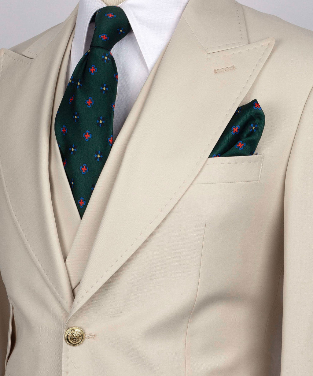 Close-up beige blazer lapel with green patterned tie and folded pocket square