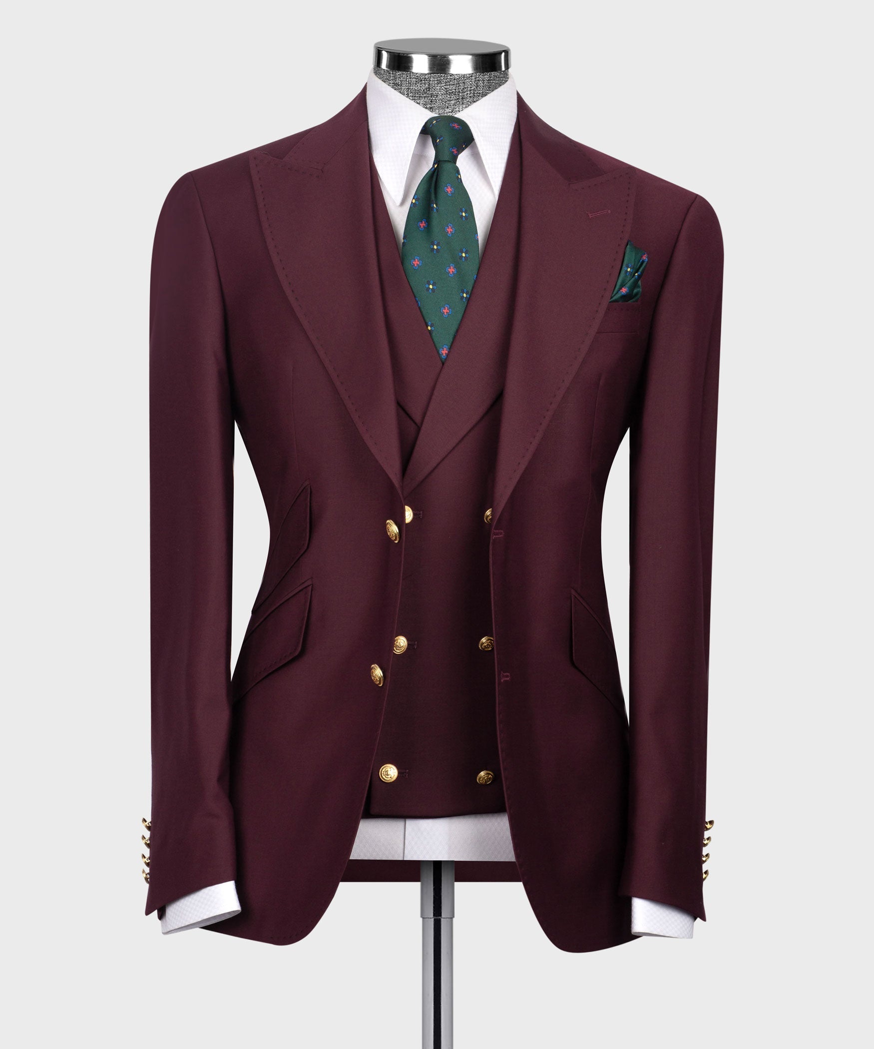 Burgundy classic three-piece suit: blazer, vest, green patterned tie, pocket square.
