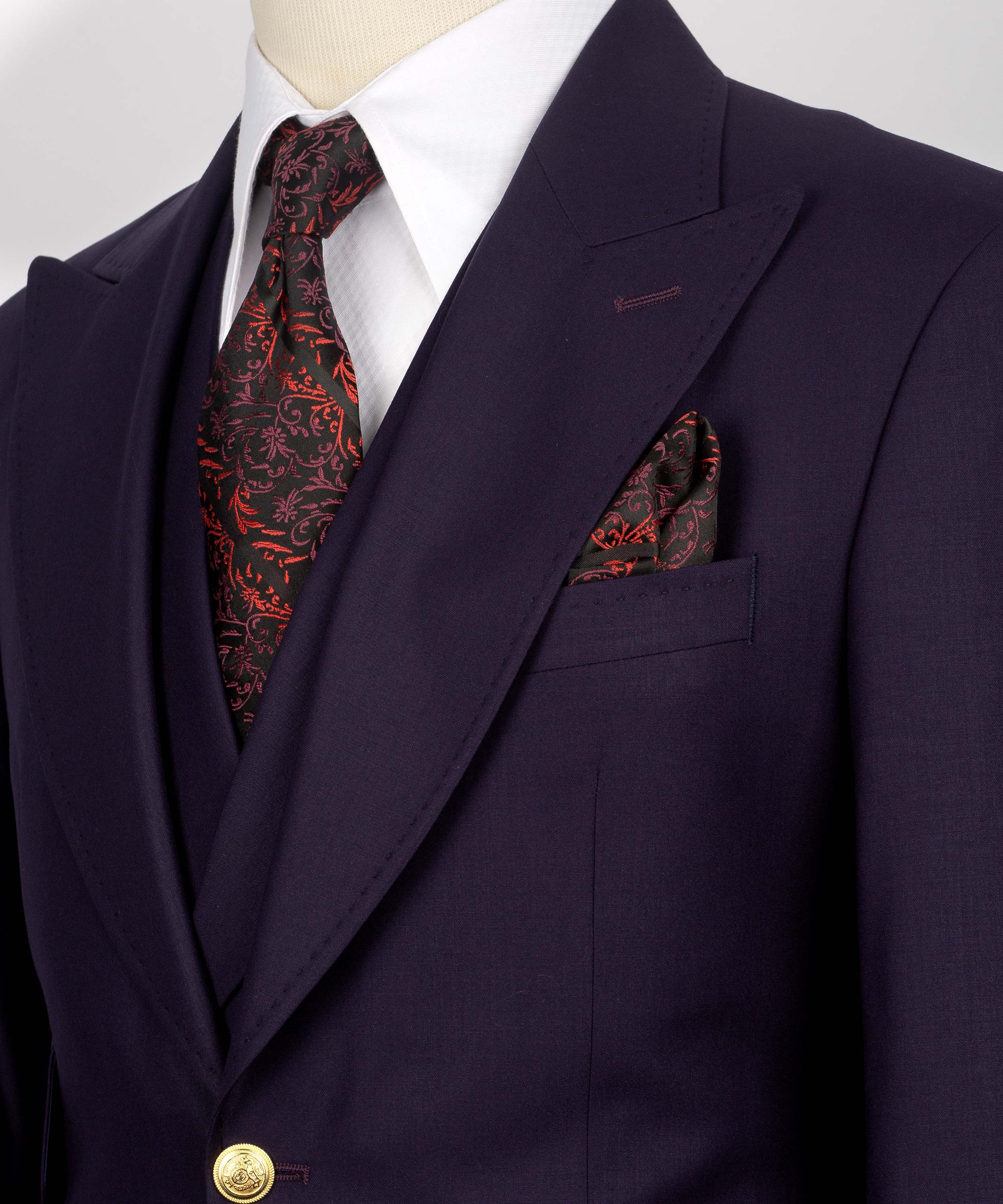 Dark purple blazer lapel with red patterned tie and matching pocket square