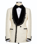 Cream tuxedo jacket with black satin lapels, bow tie, and stone-embroidered trim