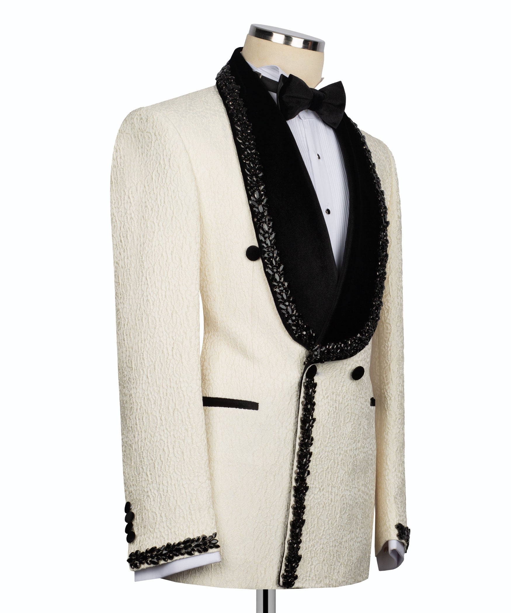 Cream tuxedo jacket profile view with black lapels, stone-fringe trim, and flap pockets