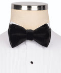 Koss Atelier black velvet bow tie on a white pleated shirt. Elegant formal style.