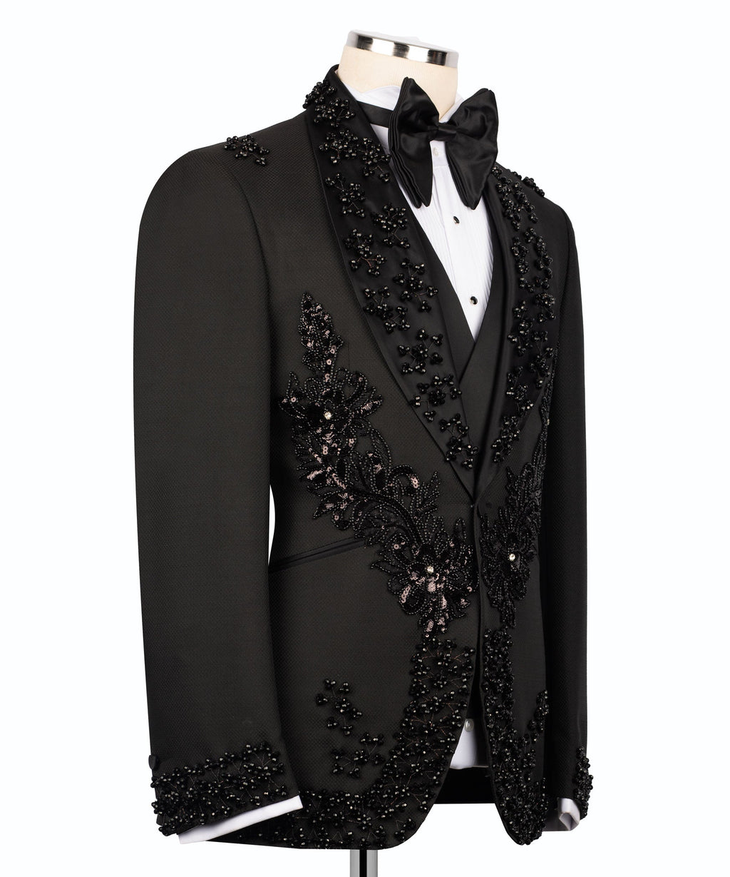Black tuxedo jacket side view with stone-embellished lapel and floral trim
