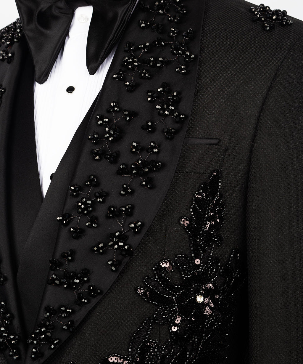 Close-up of black tuxedo lapel with scattered stone embellishments and pocket edge