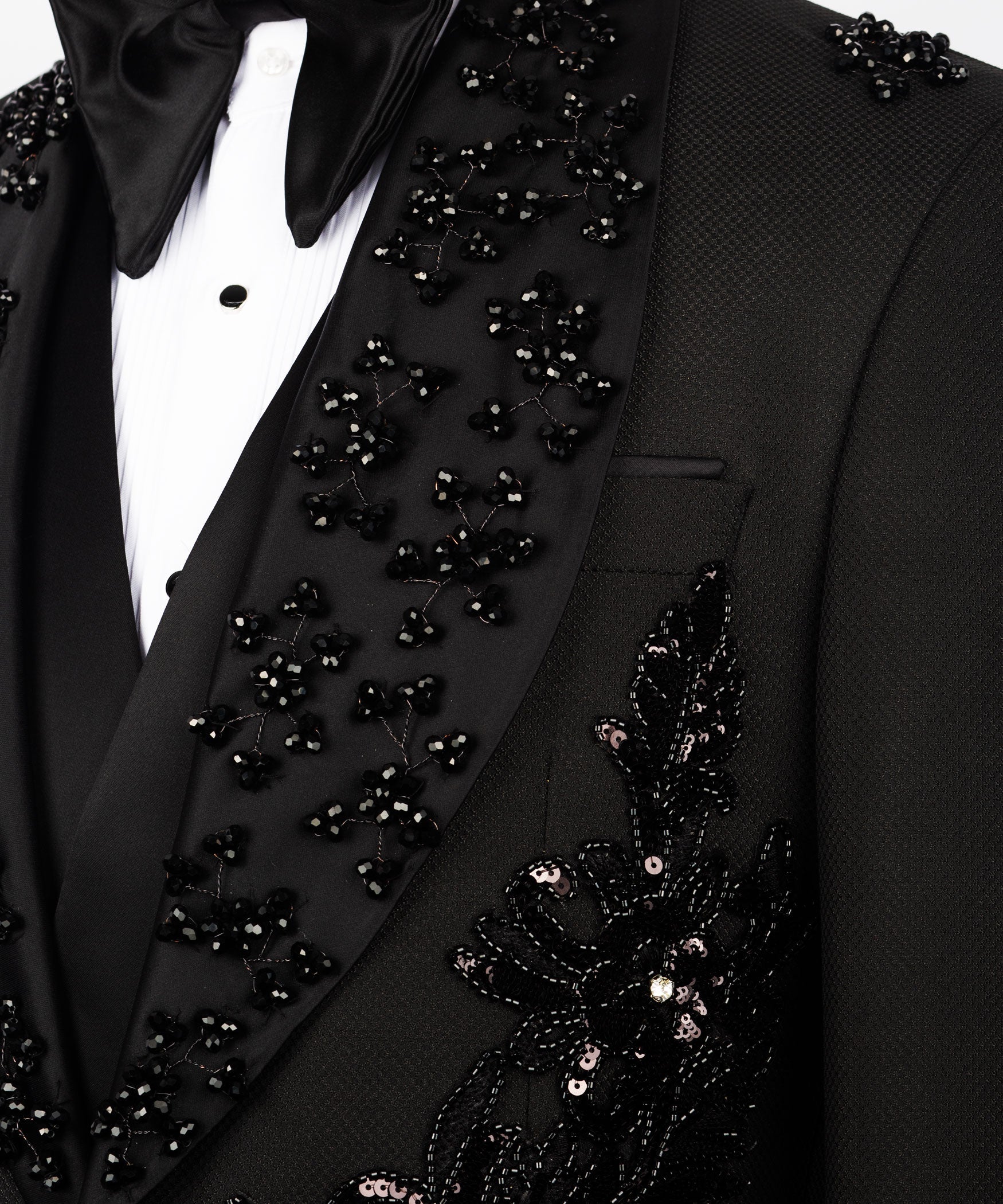 Close-up of black tuxedo lapel with scattered stone embellishments and pocket edge