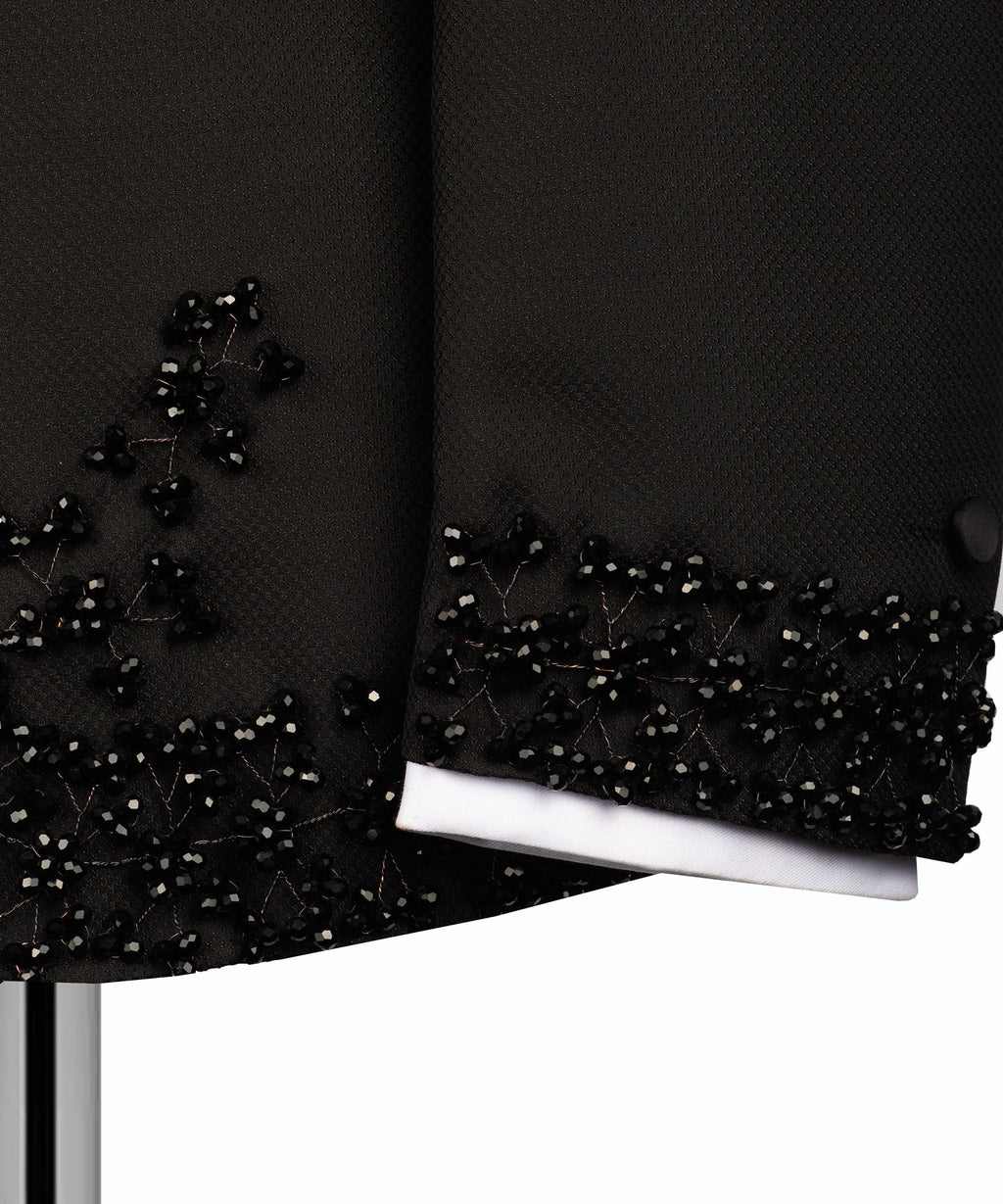 Black tuxedo sleeve cuff with beaded stone trim over white shirt cuff