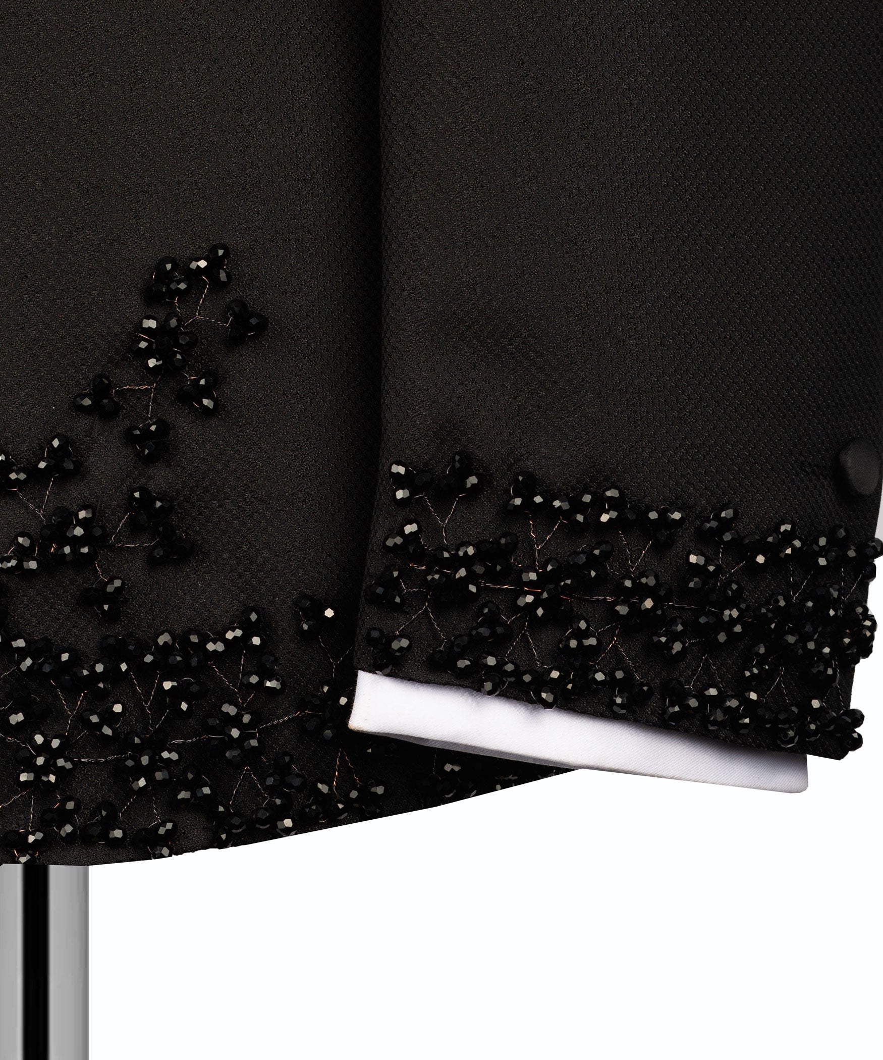 Black tuxedo sleeve cuff with beaded stone trim over white shirt cuff