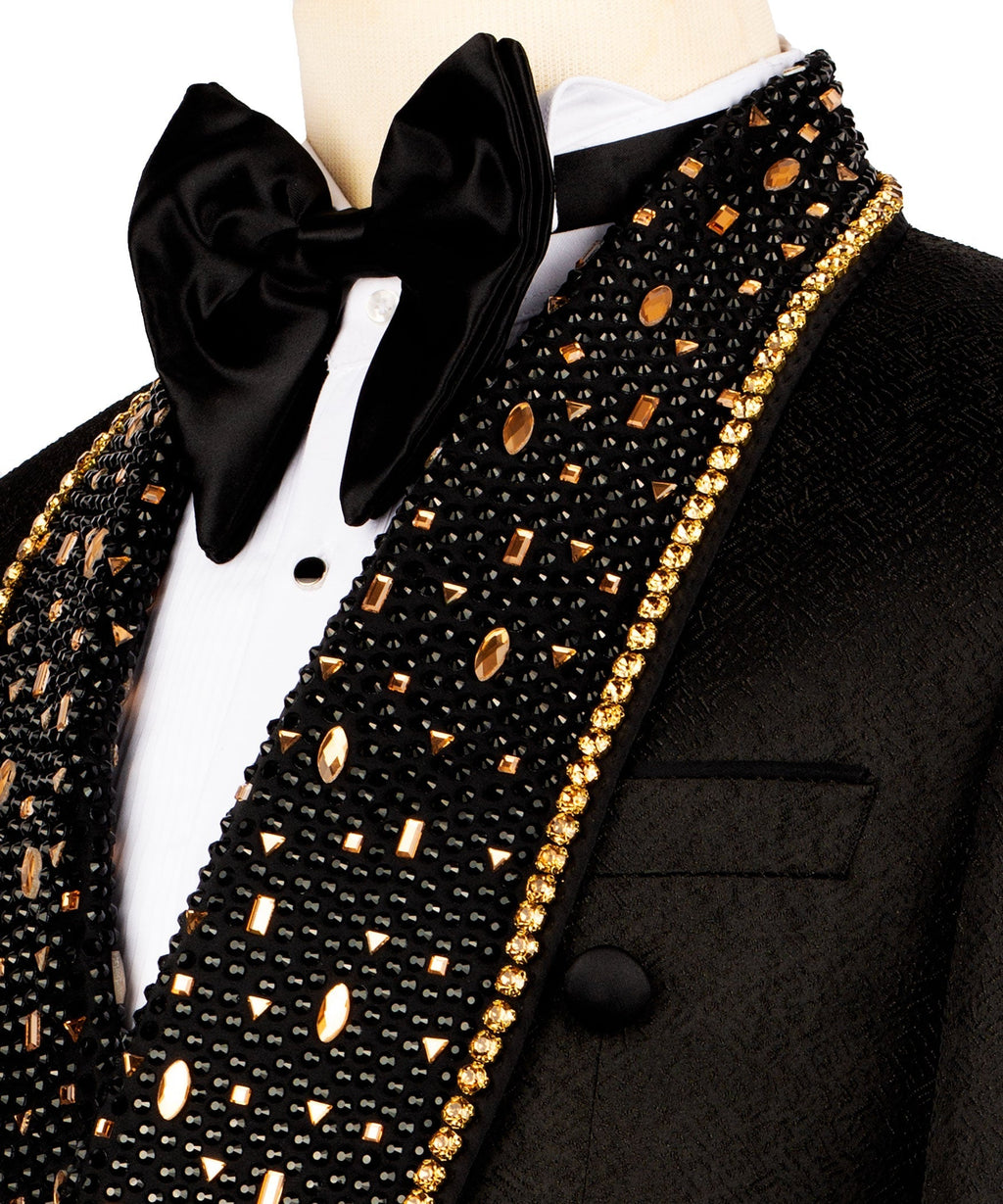 Close-up: black tuxedo lapel with gold stone embroidery and large black bow tie