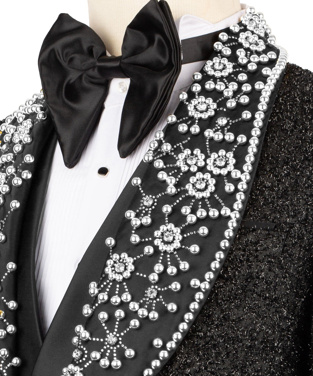 Close-up of black satin bow tie and white gem-like beaded lapel trim on tuxedo