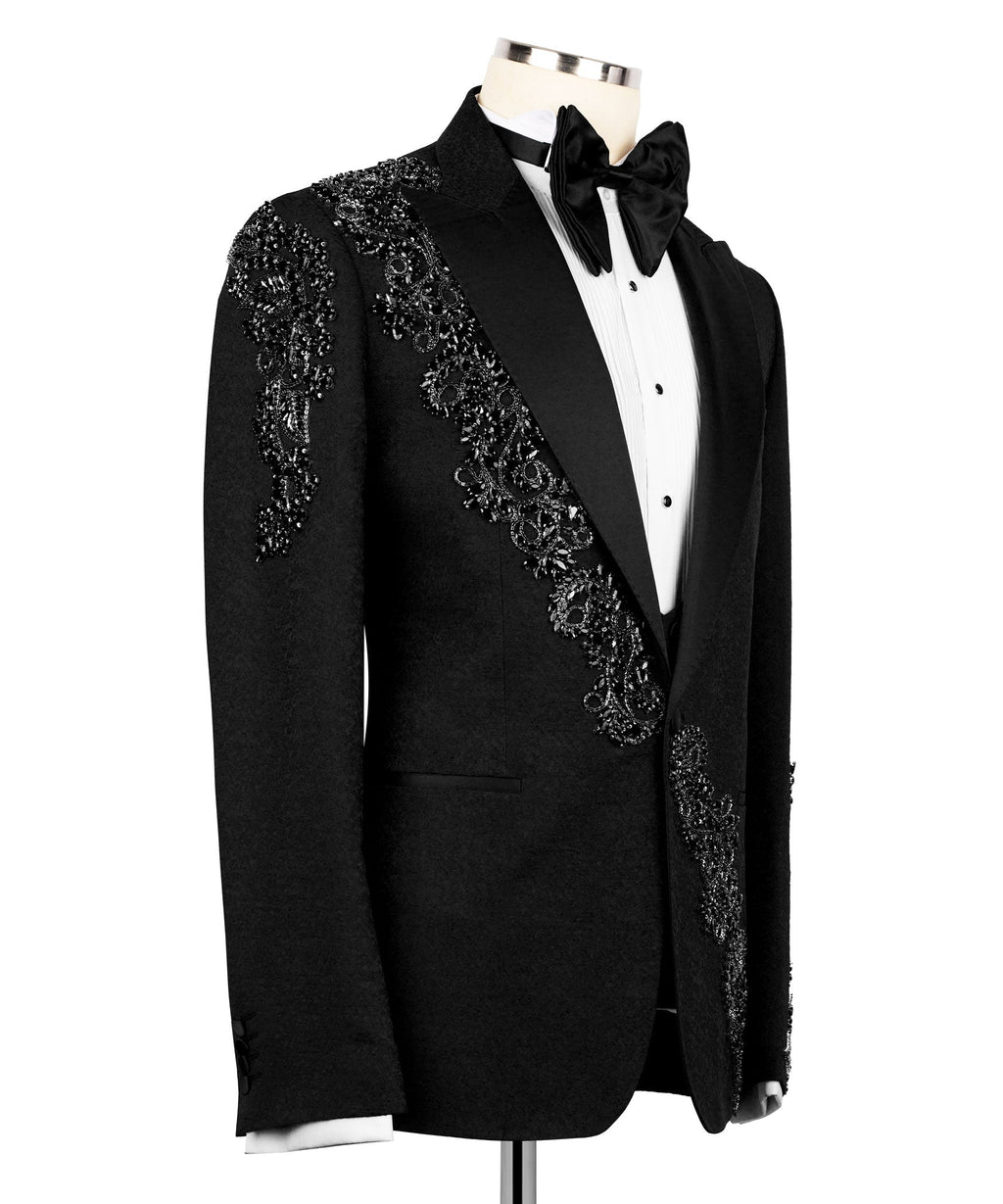 Side view: black tuxedo jacket with stone-embellished panel across shoulder