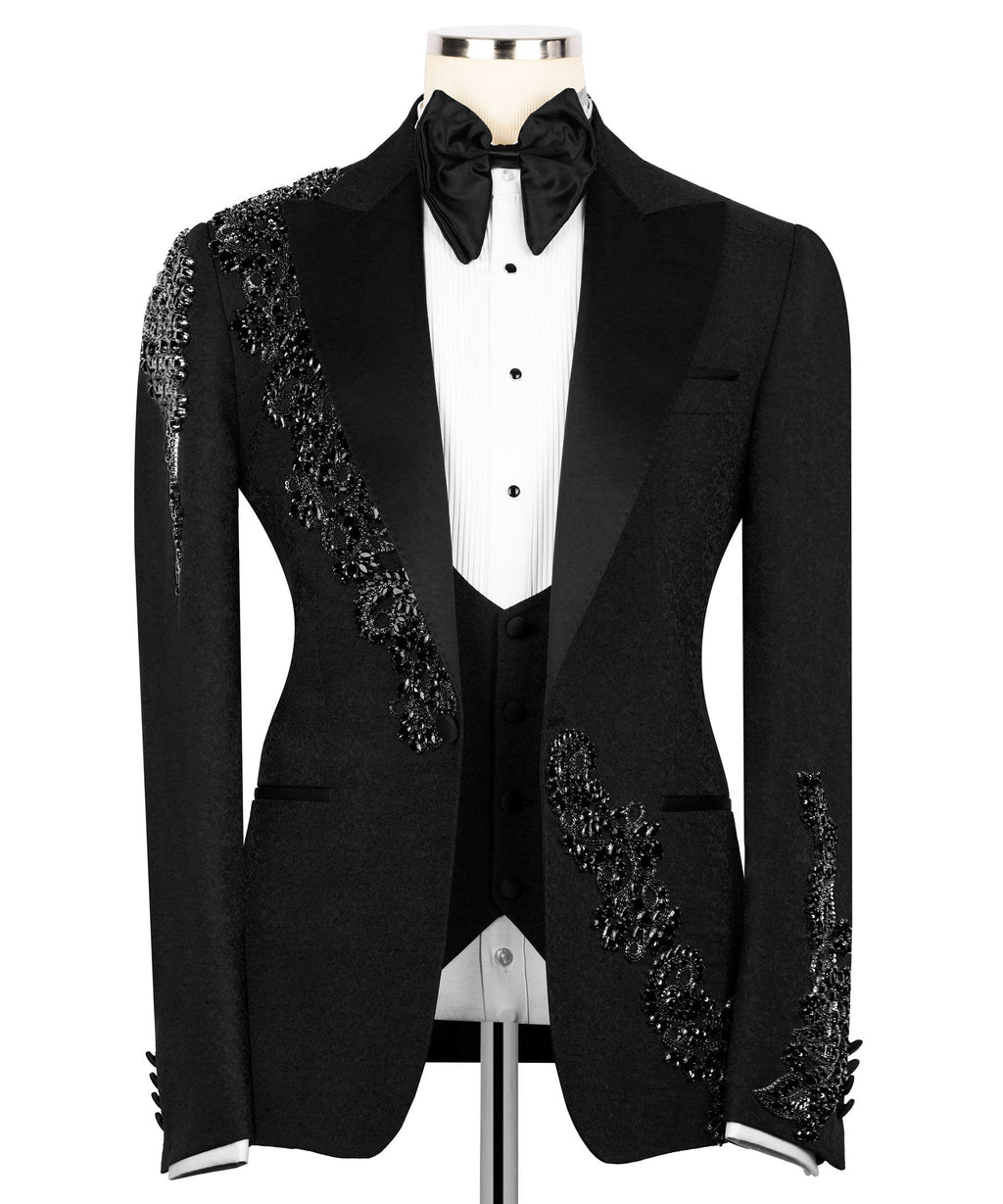 Black tuxedo blazer with white dress shirt placket, bow tie, and jeweled sleeve trim