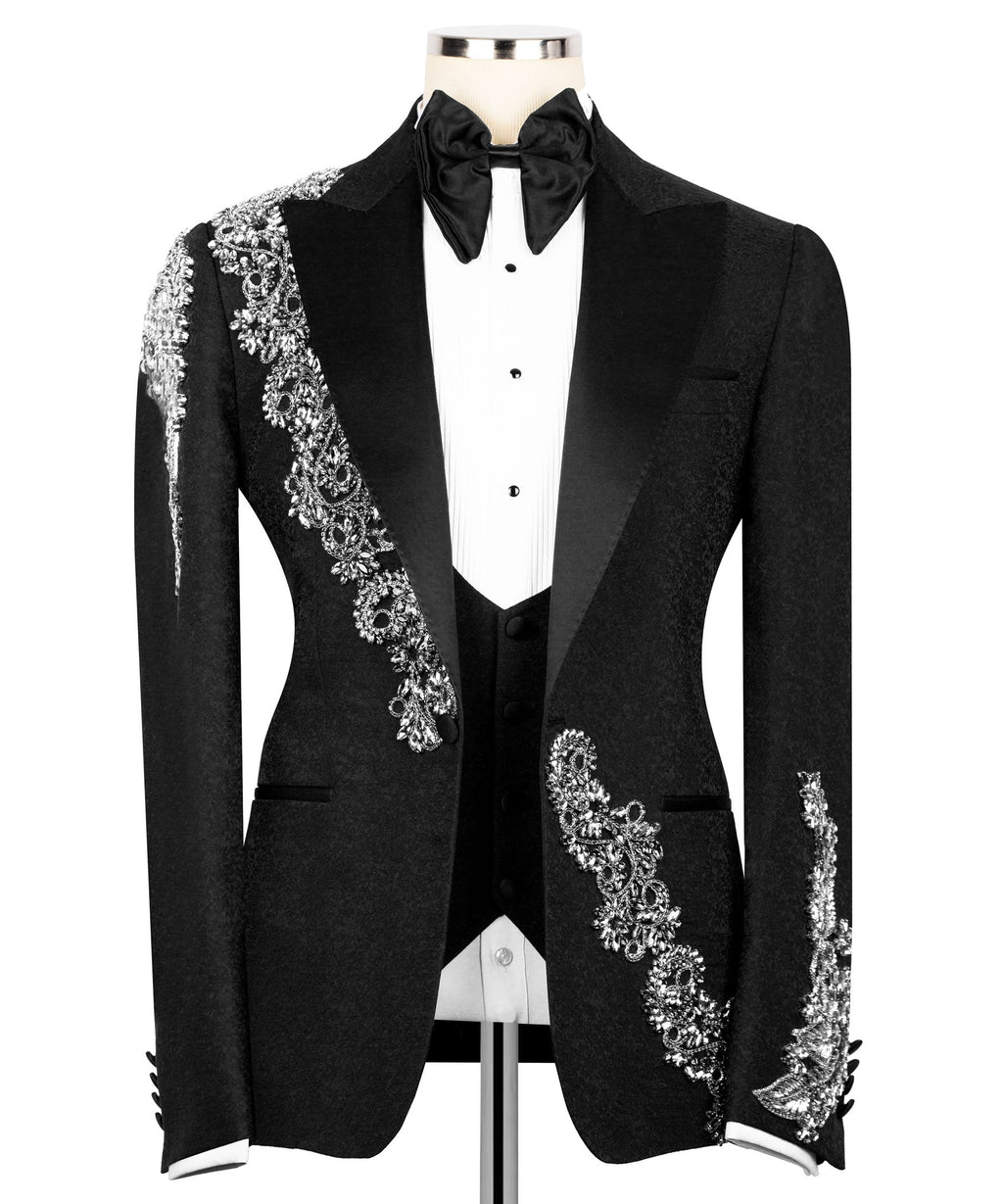 Black tuxedo jacket with silver embroidered sash, satin bow tie, and white shirt front