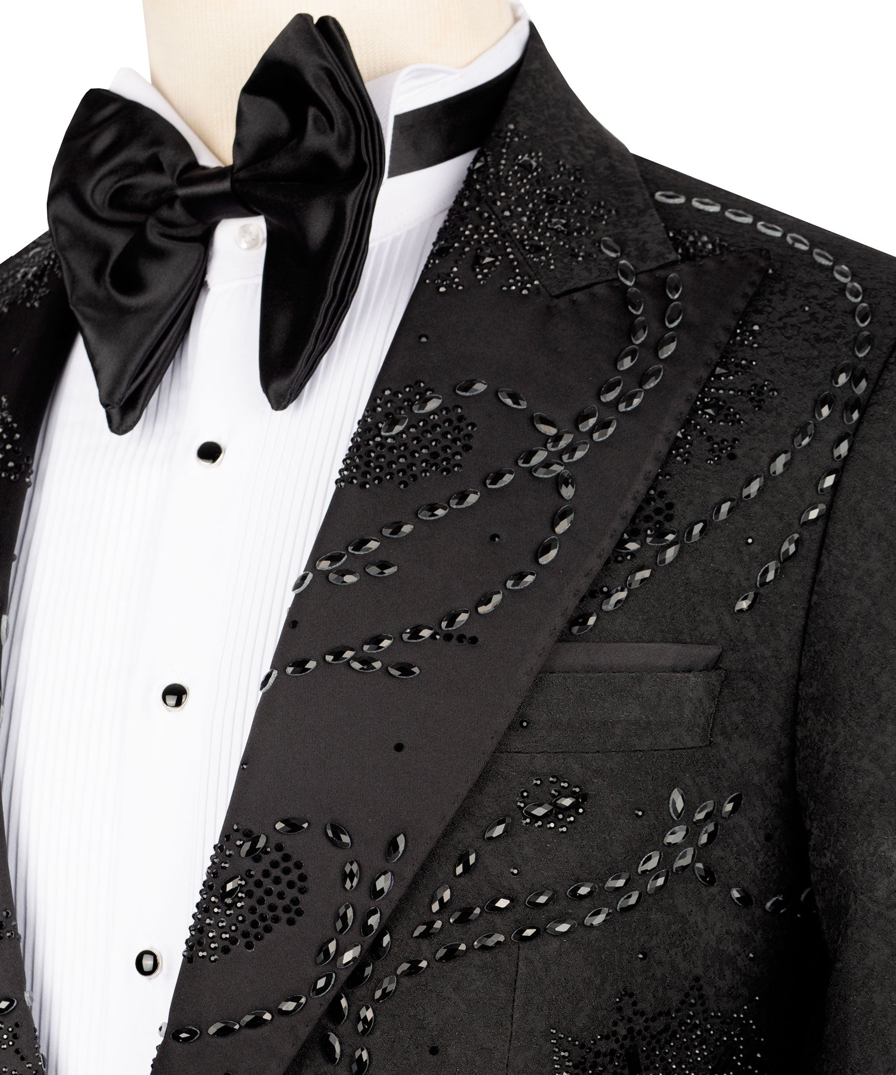Close-up: black tuxedo lapel with embroidered swirl and oval bead details plus bow tie