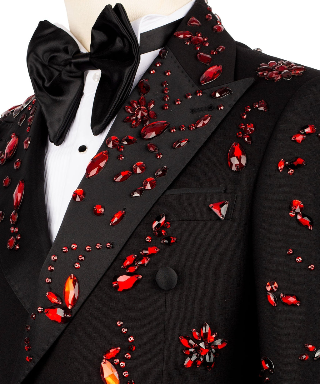 Close-up: black tuxedo lapel with red gemlike stone embroidery and satin bow tie