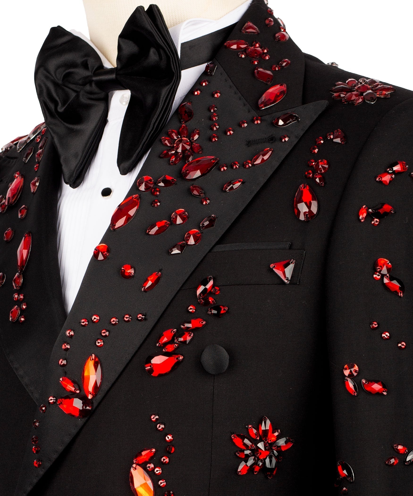 Close-up: black tuxedo lapel with red gemlike stone embroidery and satin bow tie