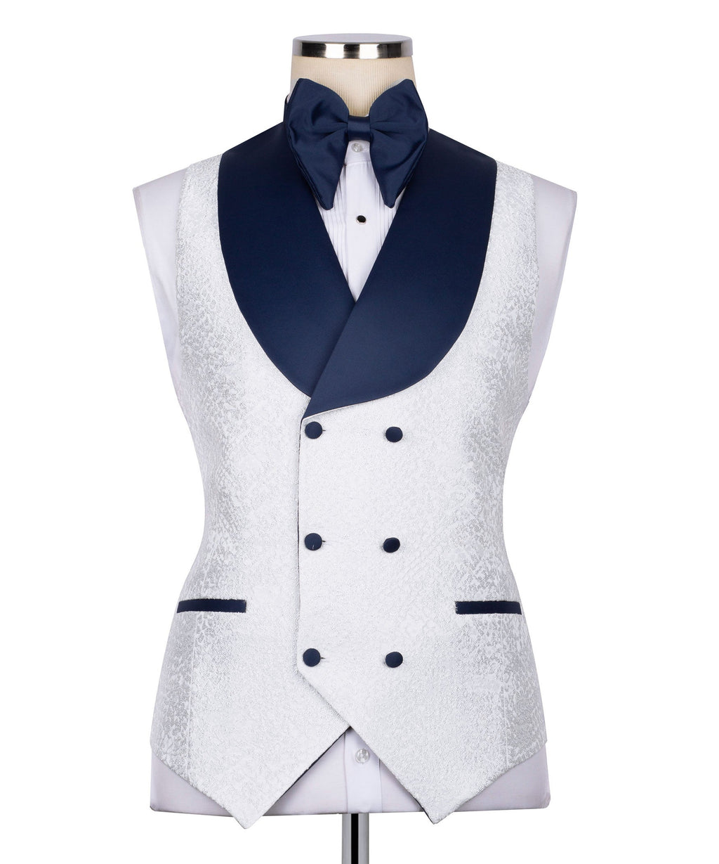 White tuxedo vest with dark blue shawl collar and double-breasted navy buttons.