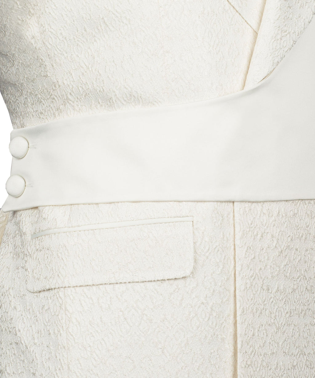 Close-up of cream tuxedo vest and trousers with round vest buttons and pocket flaps