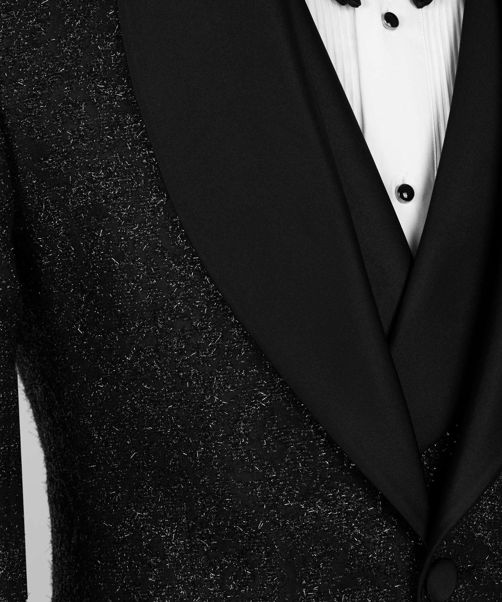 Close-up of black glitter lapel and satin V-neck tuxedo front with button