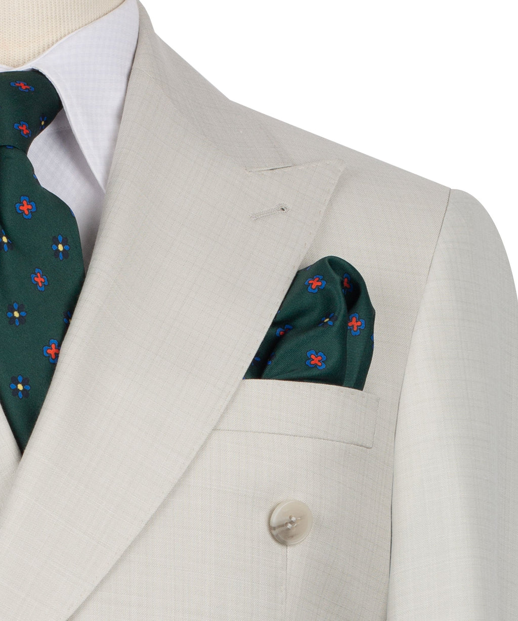 Beige blazer close-up: pocket square and green patterned tie at the lapel