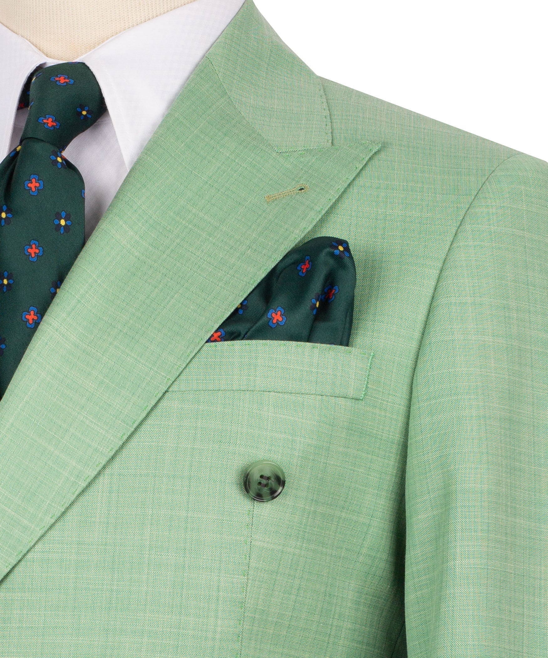 Light green suit jacket lapel detail with dark pocket square and round engraved buttons
