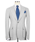 Light gray linen blazer with notch lapels, blue patterned tie, and matching pocket square