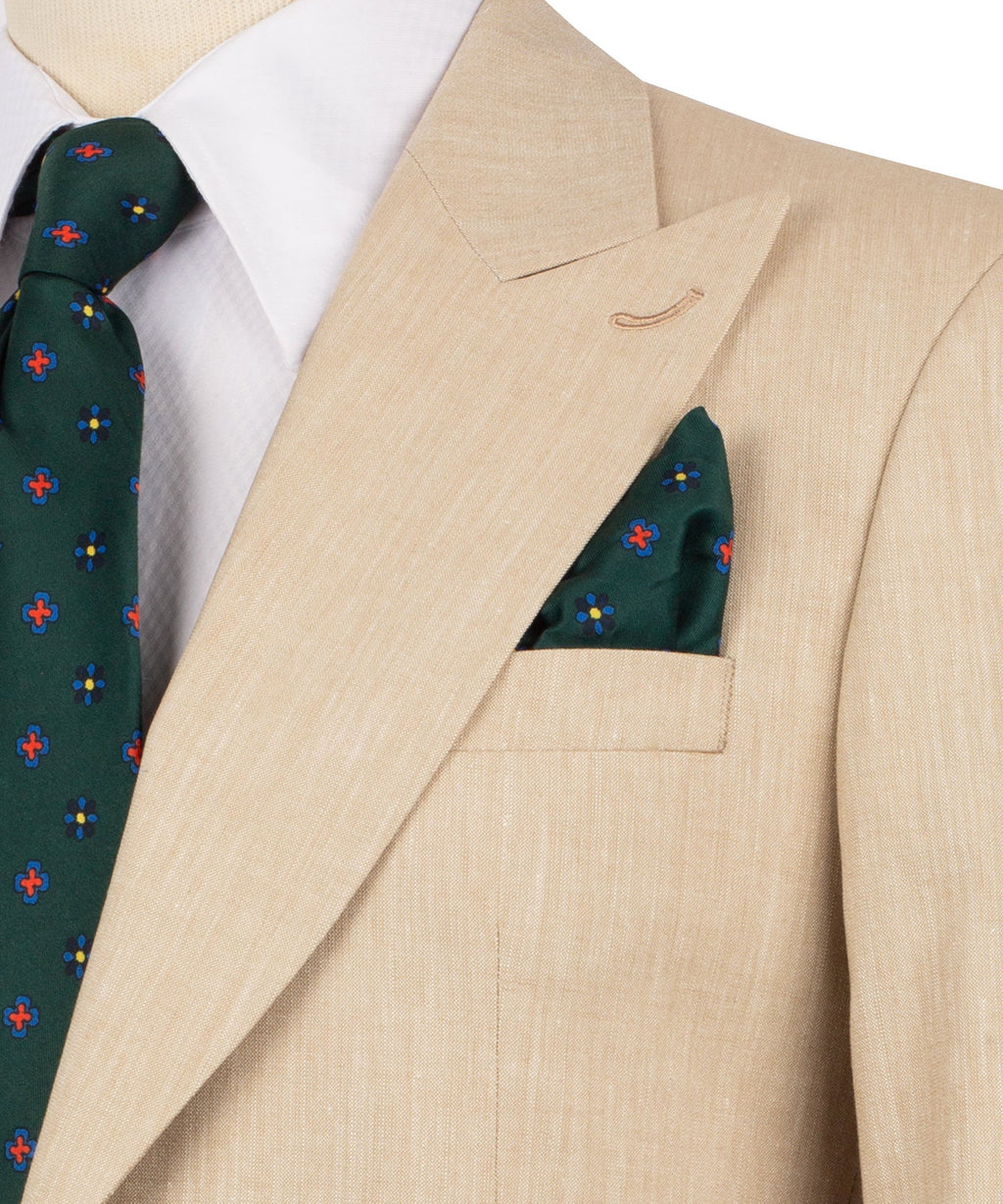 Beige linen suit jacket close-up: notch lapel, chest pocket, green patterned pocket square