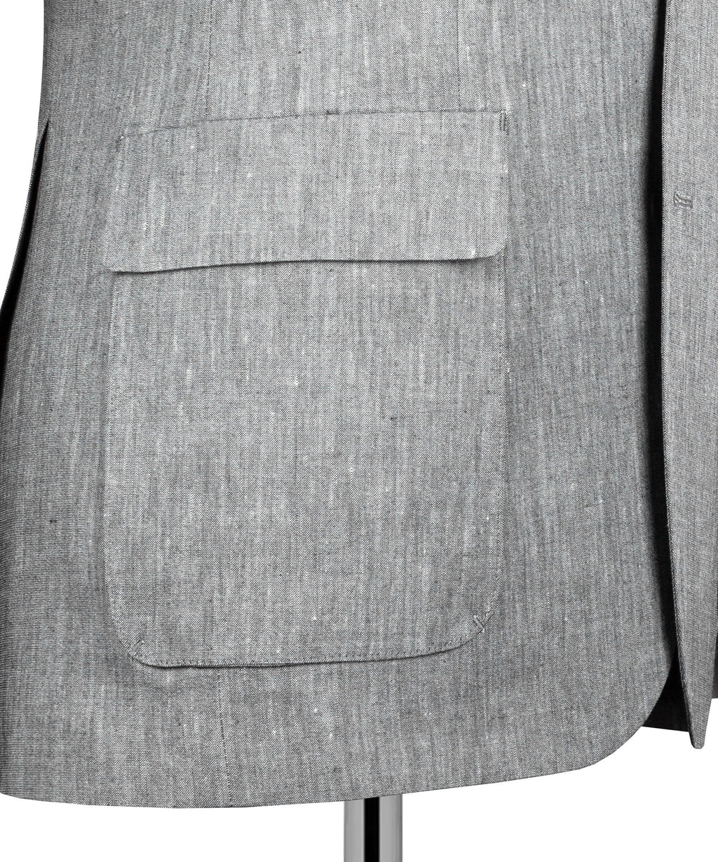 Gray suit jacket front pocket detail with flap and single button
